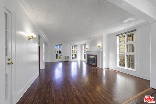 unfurnished living room with dark hardwood / wood-style flooring, ornamental molding, and a textured ceiling