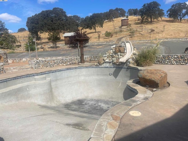 view of swimming pool featuring a water slide and a rural view