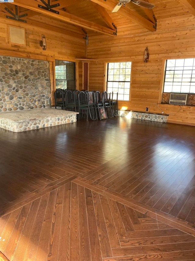 interior space featuring ceiling fan, wooden walls, beam ceiling, and high vaulted ceiling