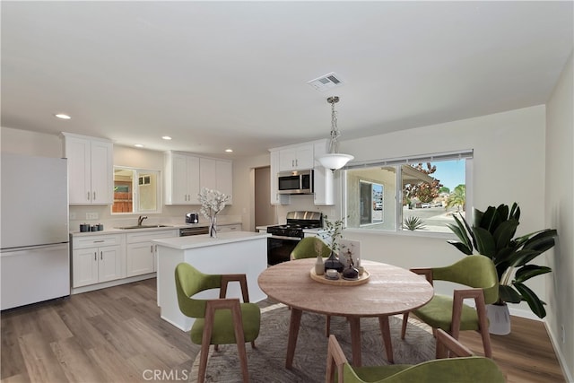 dining space with hardwood / wood-style floors and sink