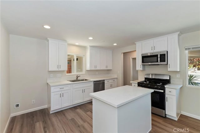 74761 Leslie Ave, Palm Desert, CA 92260 - kitchen with appliances with stainless steel finishes, white cabinetry, wood finished floors, light countertops, and a kitchen island