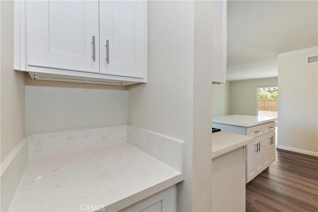 kitchen featuring white cabinets and dark wood-type flooring