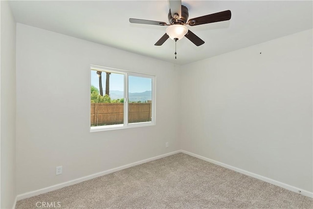 unfurnished room featuring light colored carpet and ceiling fan