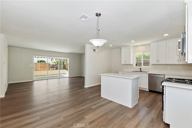 74761 Leslie Ave, Palm Desert, CA 92260 - kitchen featuring stainless steel dishwasher, white range oven, open floor plan, a center island, and white cabinetry