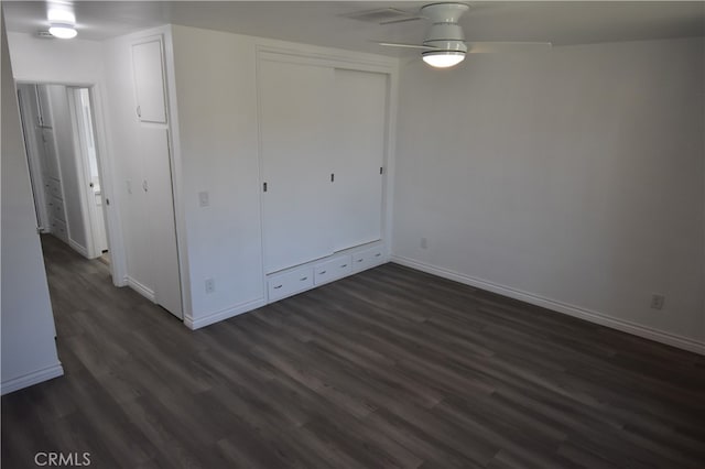 unfurnished bedroom with ceiling fan, a closet, and dark hardwood / wood-style flooring