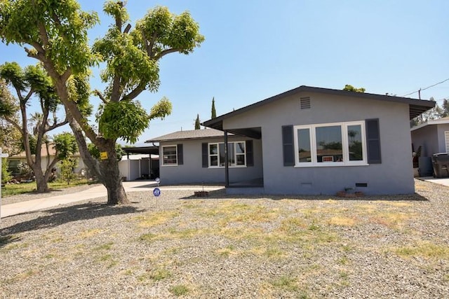 rear view of property with crawl space and stucco siding