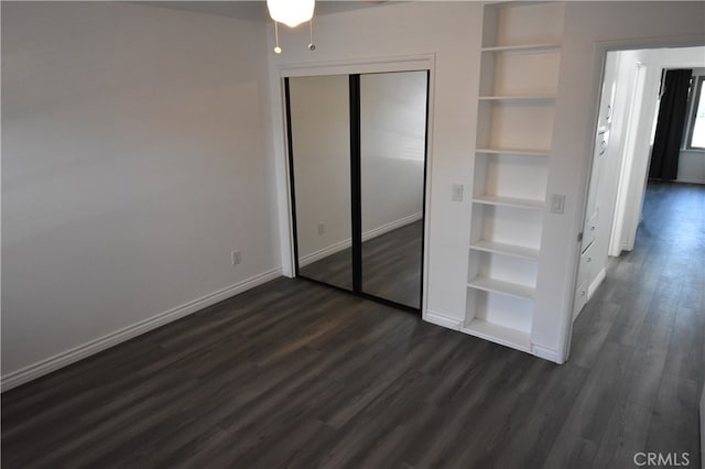 unfurnished bedroom featuring dark wood-type flooring and a closet