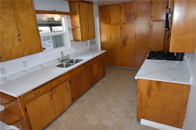 kitchen featuring black range, light tile patterned flooring, and sink