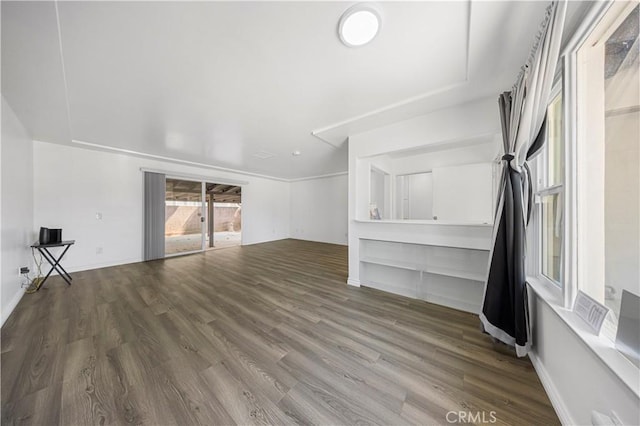 unfurnished living room with baseboards and wood finished floors