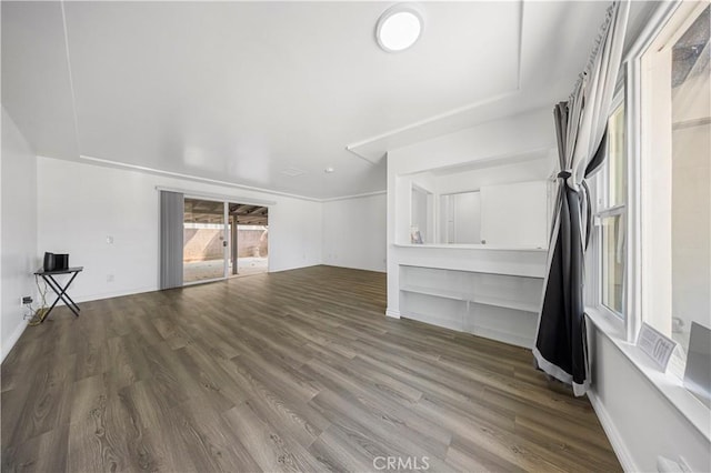 unfurnished living room with wood finished floors and baseboards