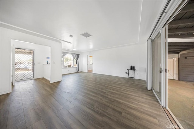 unfurnished living room featuring dark wood-style flooring, visible vents, and baseboards