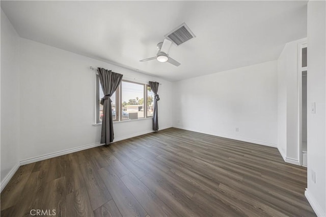 spare room featuring a ceiling fan, baseboards, visible vents, and dark wood-style flooring