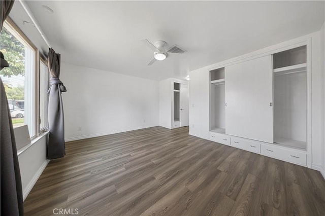 unfurnished bedroom featuring a ceiling fan, baseboards, visible vents, and wood finished floors