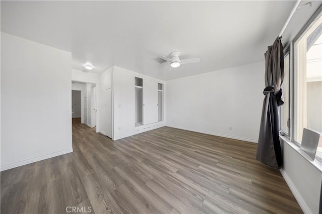 unfurnished living room featuring baseboards, a ceiling fan, wood finished floors, and visible vents