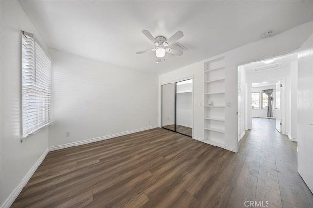 unfurnished bedroom featuring a ceiling fan, baseboards, a closet, and dark wood finished floors