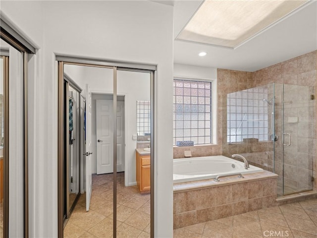 bathroom featuring tile patterned flooring, shower with separate bathtub, and vanity