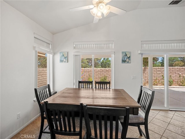 tiled dining room with a wealth of natural light, ceiling fan, and lofted ceiling