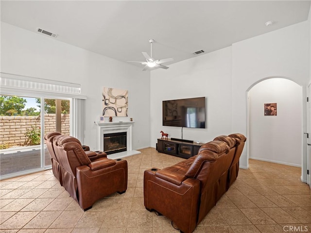 living room featuring a high ceiling, ceiling fan, and light tile patterned flooring