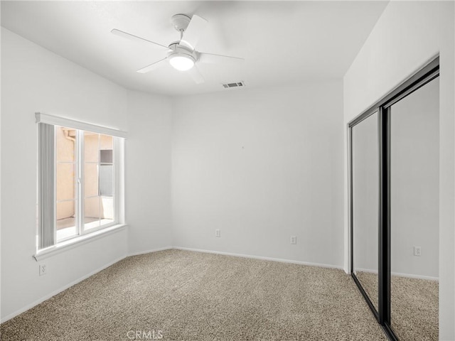 unfurnished bedroom featuring carpet, a closet, and ceiling fan