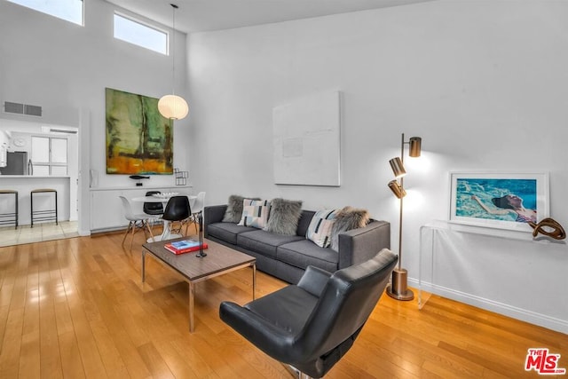 living room with a high ceiling and hardwood / wood-style flooring