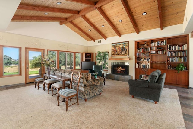 living room with high vaulted ceiling, beamed ceiling, a tile fireplace, and wooden ceiling