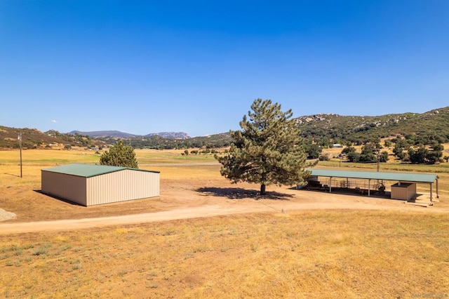 exterior space with a mountain view, a rural view, and an outdoor structure