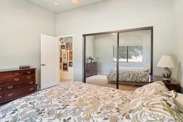 carpeted bedroom featuring ceiling fan and a closet