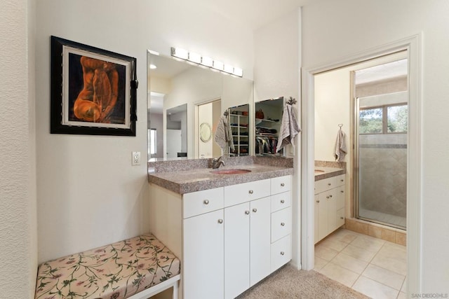 bathroom with tile patterned flooring, a shower with shower door, and vanity