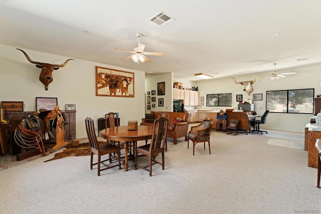 dining area featuring ceiling fan and light carpet