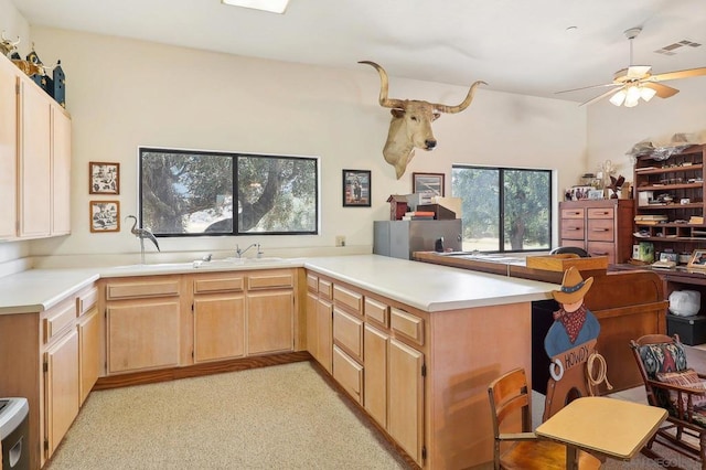 kitchen featuring kitchen peninsula, light brown cabinets, ceiling fan, and sink