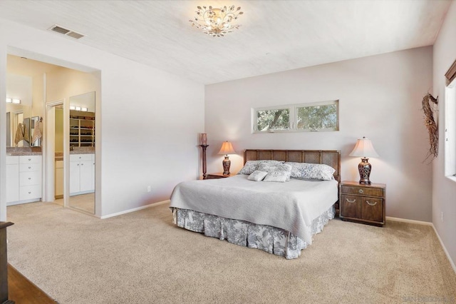 carpeted bedroom featuring a closet, a walk in closet, and ensuite bathroom