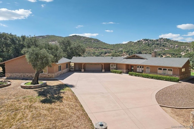 ranch-style home with a garage and a mountain view