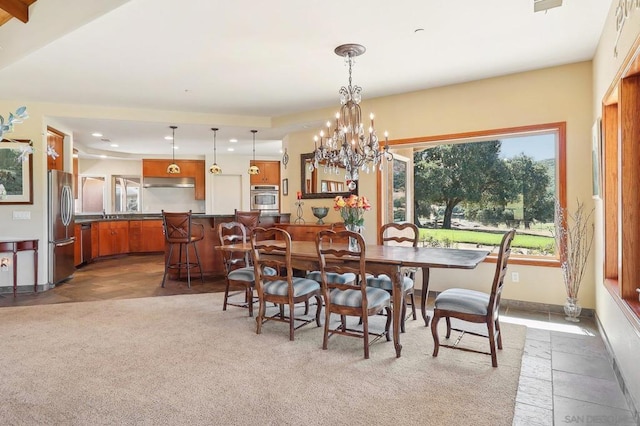 carpeted dining space with a chandelier