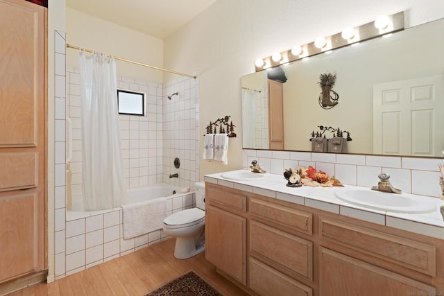 full bathroom with hardwood / wood-style flooring, decorative backsplash, shower / tub combo with curtain, vanity, and toilet