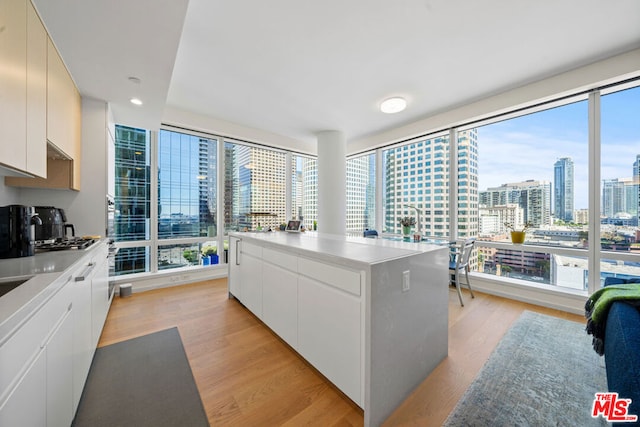 kitchen with white cabinetry, light hardwood / wood-style floors, and a healthy amount of sunlight