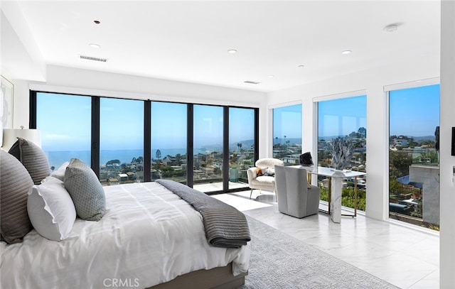 bedroom featuring multiple windows and a water view