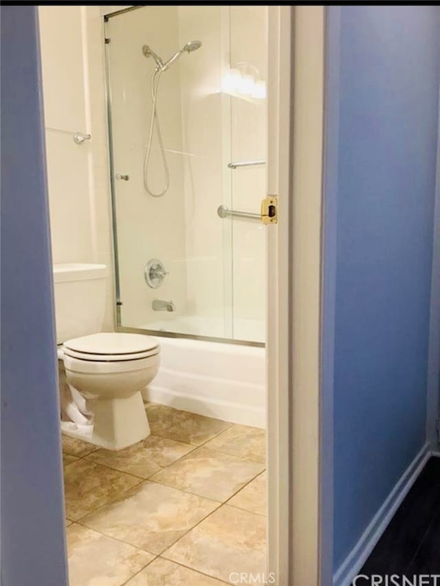 bathroom with enclosed tub / shower combo, toilet, and tile patterned floors