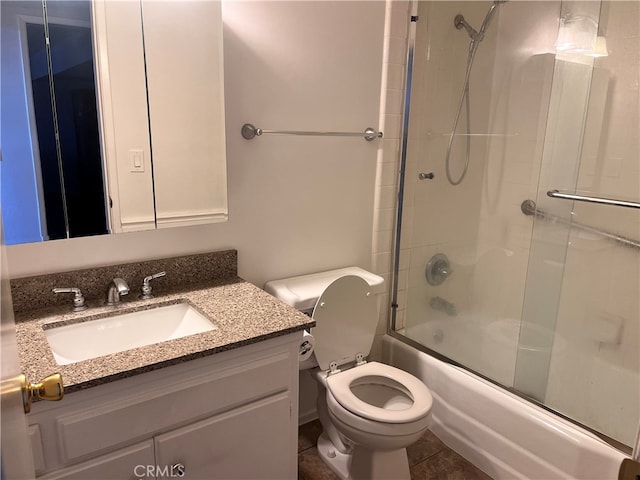 full bathroom featuring tile patterned floors, shower / bath combination with glass door, vanity, and toilet