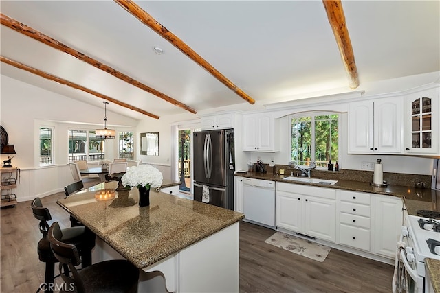 kitchen featuring lofted ceiling with beams, pendant lighting, sink, white cabinetry, and white appliances