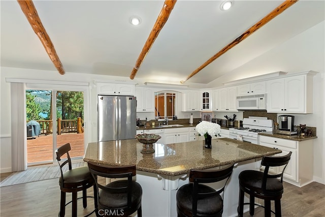 kitchen featuring lofted ceiling with beams, wood-type flooring, white appliances, and white cabinetry