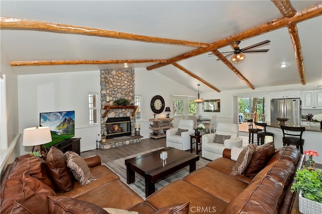 living room with vaulted ceiling with beams, a fireplace, hardwood / wood-style floors, and ceiling fan