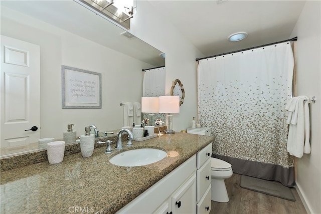 bathroom featuring vanity, toilet, and hardwood / wood-style flooring