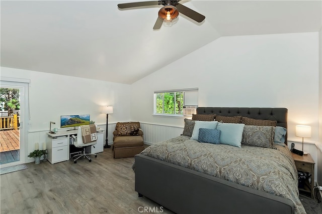 bedroom featuring access to outside, vaulted ceiling, hardwood / wood-style floors, and multiple windows