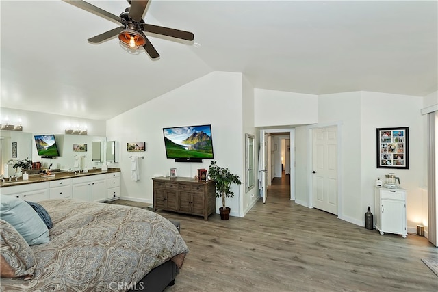 bedroom with ceiling fan, lofted ceiling, and wood-type flooring