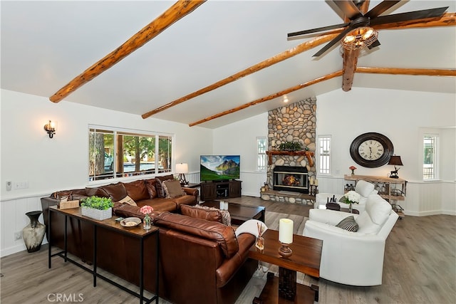 living room with vaulted ceiling with beams, ceiling fan, a fireplace, and hardwood / wood-style floors