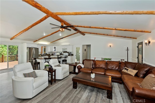 living room with ceiling fan, lofted ceiling with beams, and light hardwood / wood-style floors