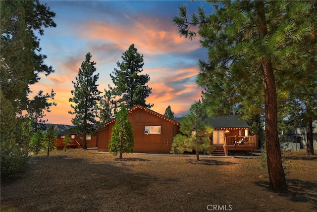 property exterior at dusk featuring a deck