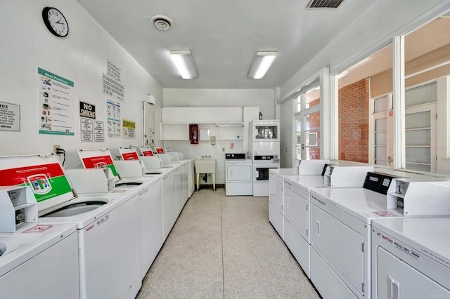 clothes washing area with separate washer and dryer and sink