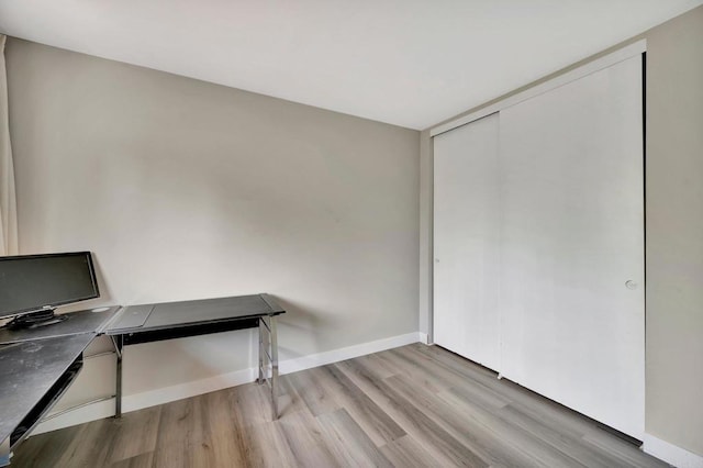 office area featuring light wood-type flooring and baseboards