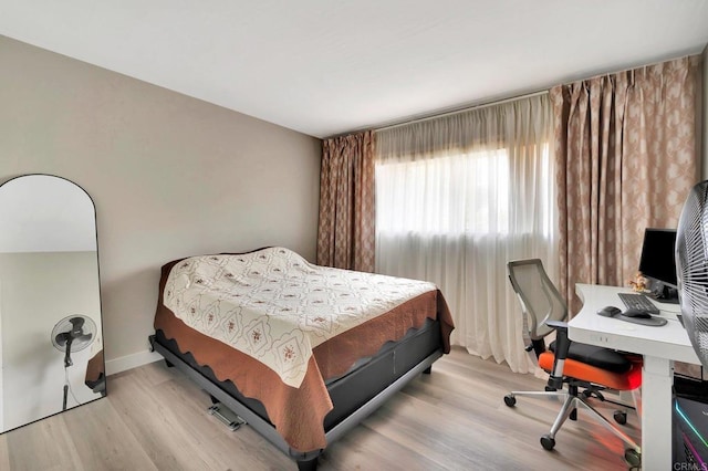 bedroom with baseboards and light wood-style floors